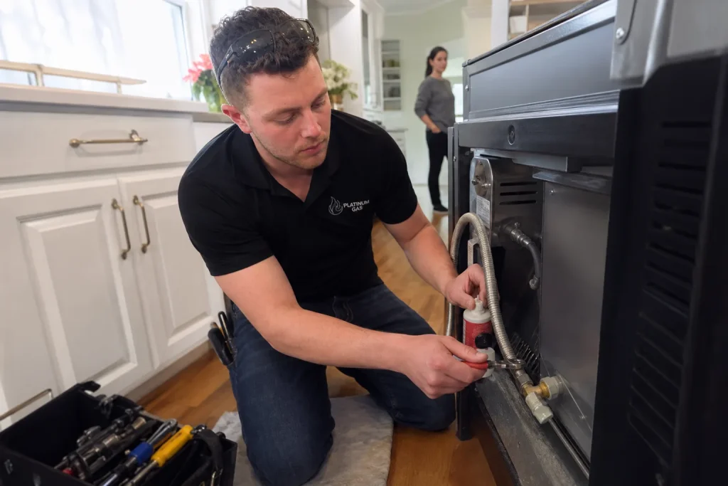 Reilly checking a gas range connection - Platinum Gas Reilly Morrison checking the final connection on a residential gas range