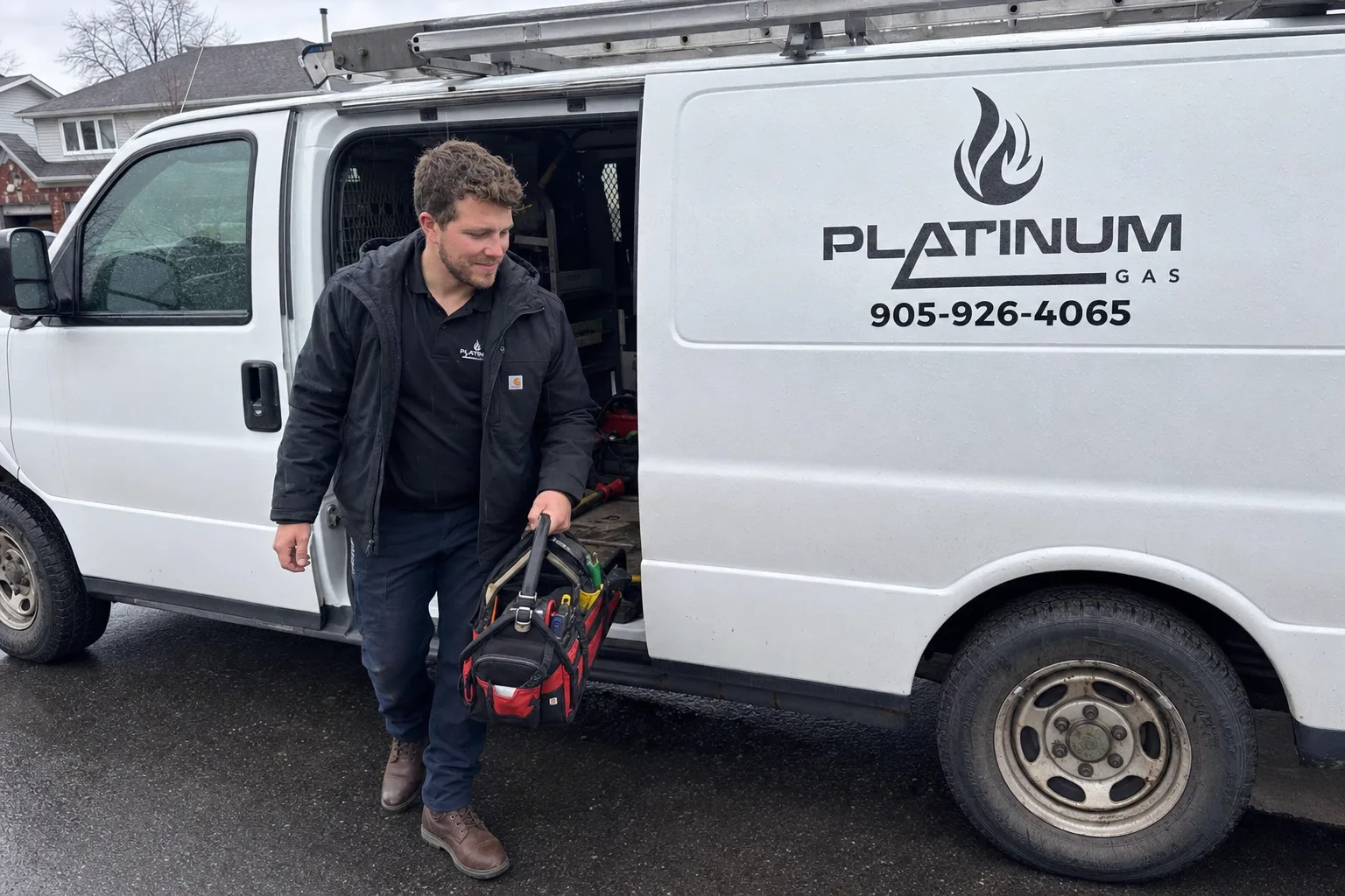 Reilly Morrison loading tools into the branded Platinum Gas service van on a rainy day