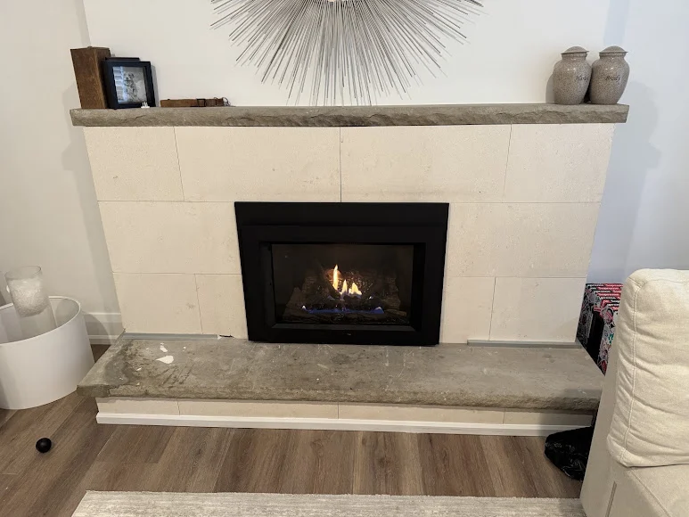 Gas fireplace insert set into a light limestone fireplace surround - Platinum Gas Gas fireplace insert set into a light limestone fireplace surround
