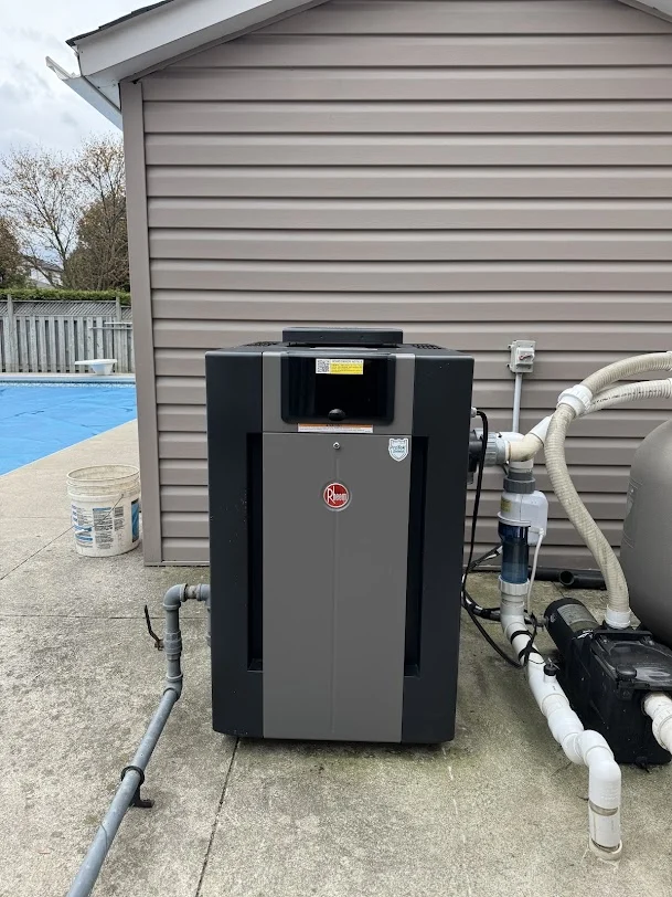 Outdoor gas pool heater connected to pool equipment beside the house